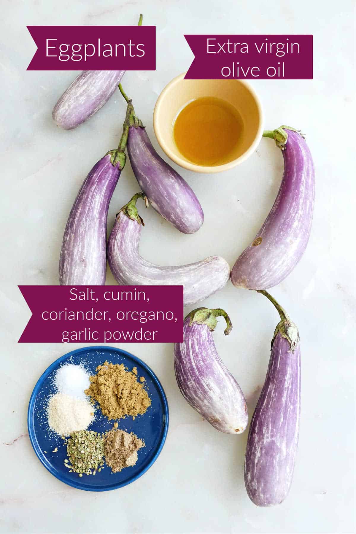 Fairy tale eggplants, olive oil, and spices on a counter with labels.