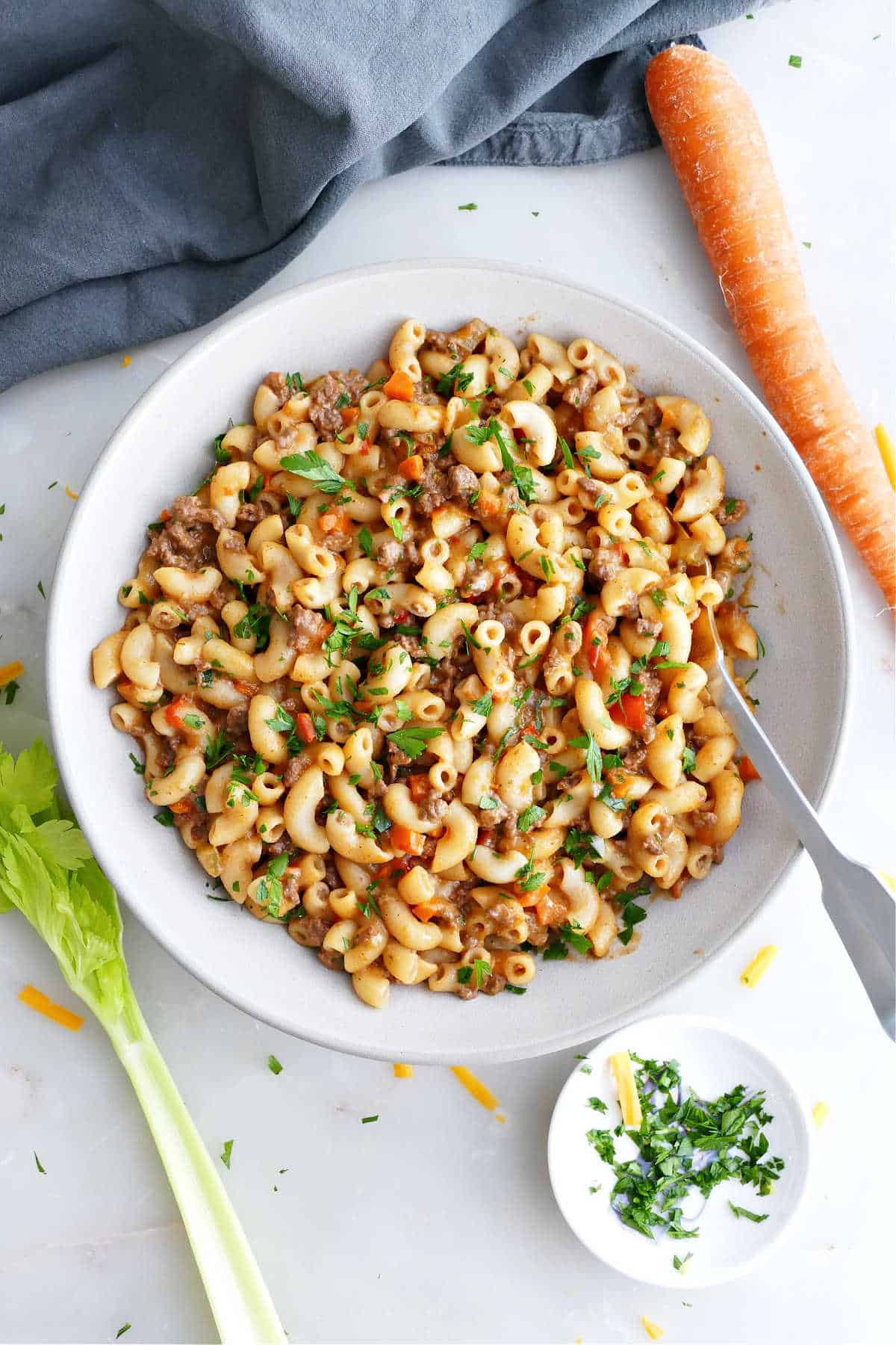 Healthier hamburger helper in a serving bowl next to ingredients.