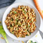 Healthier hamburger helper in a serving bowl next to ingredients.