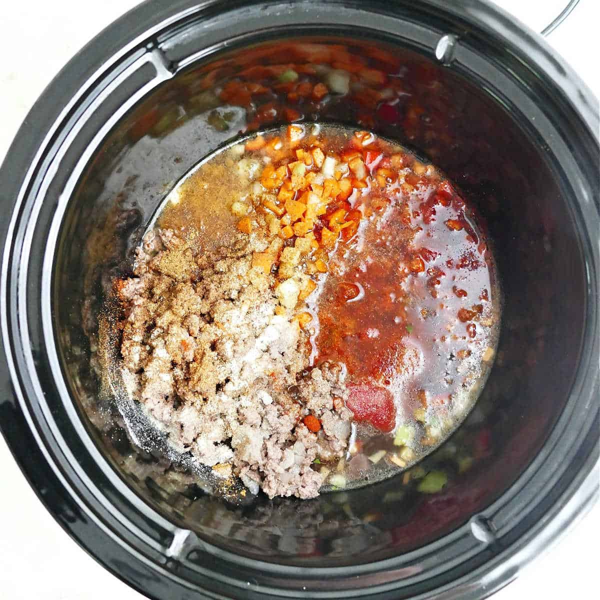 Ground beef, chopped veggies, tomato paste, spices, and beef broth in a Crock-Pot.