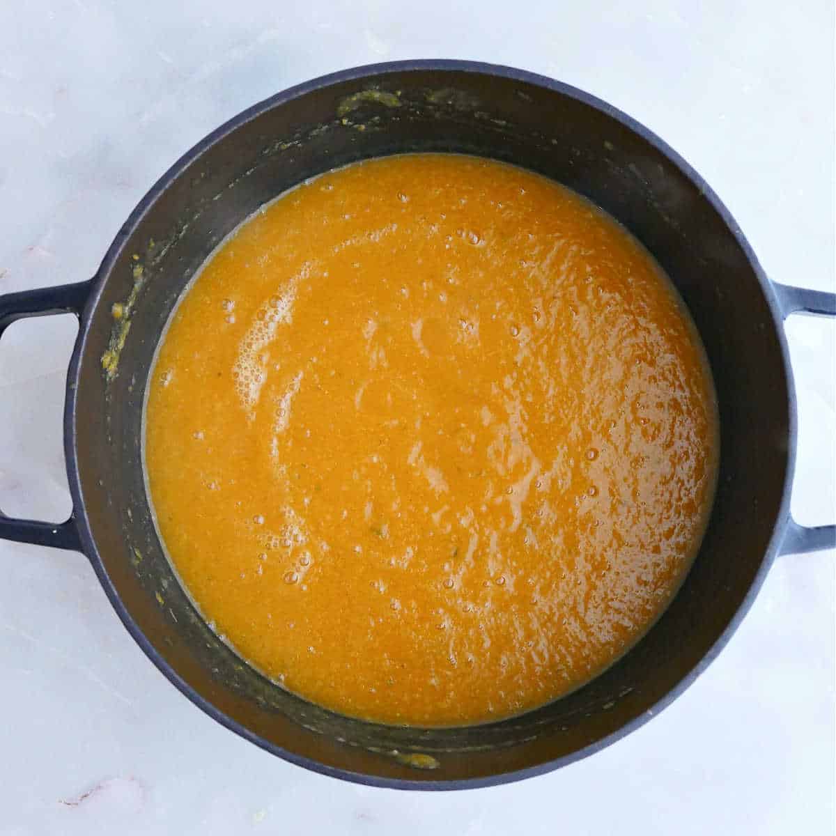 Apple carrot ginger soup blended in a soup pot after cooking.