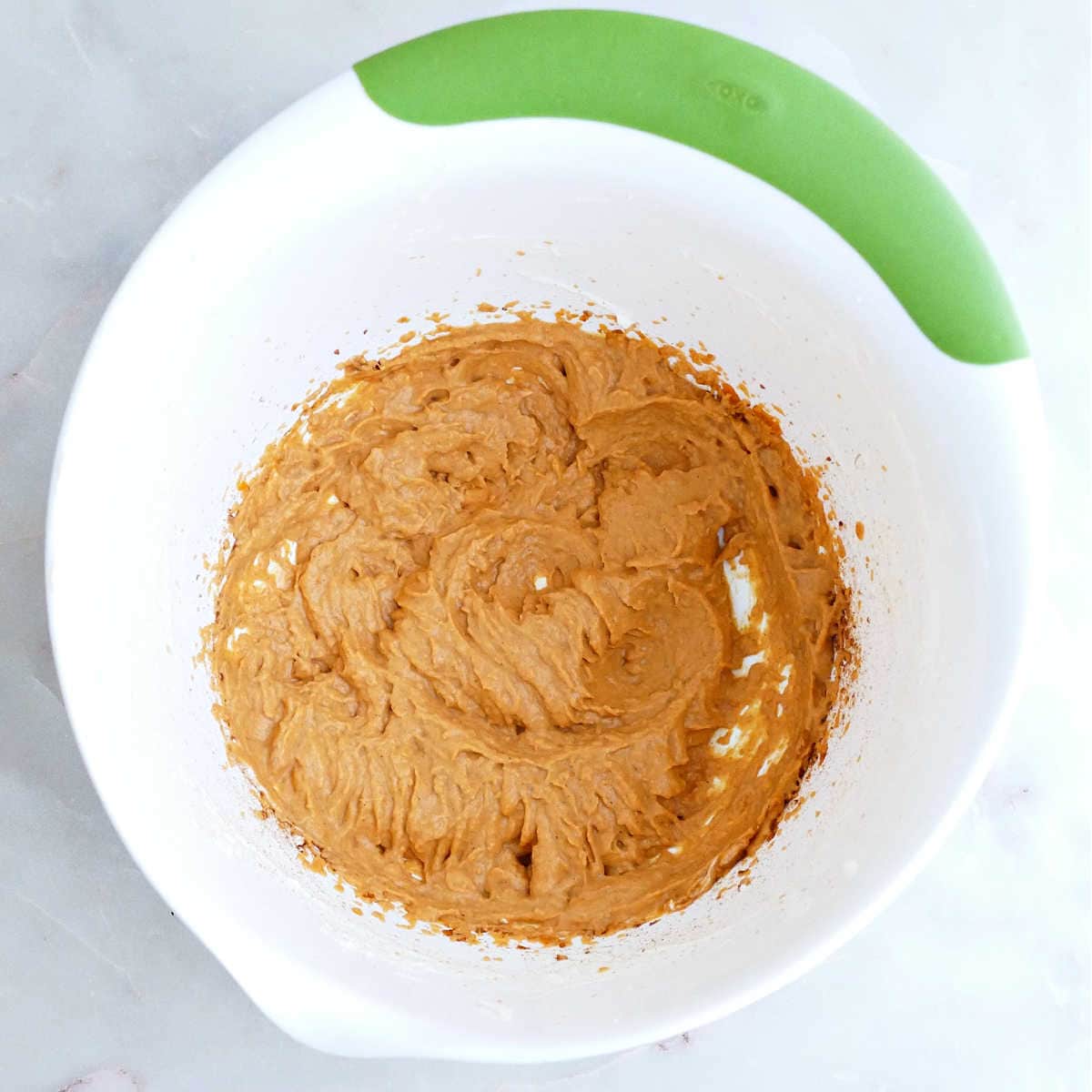 Pumpkin puree whipped with maple syrup and vanilla in a mixing bowl.