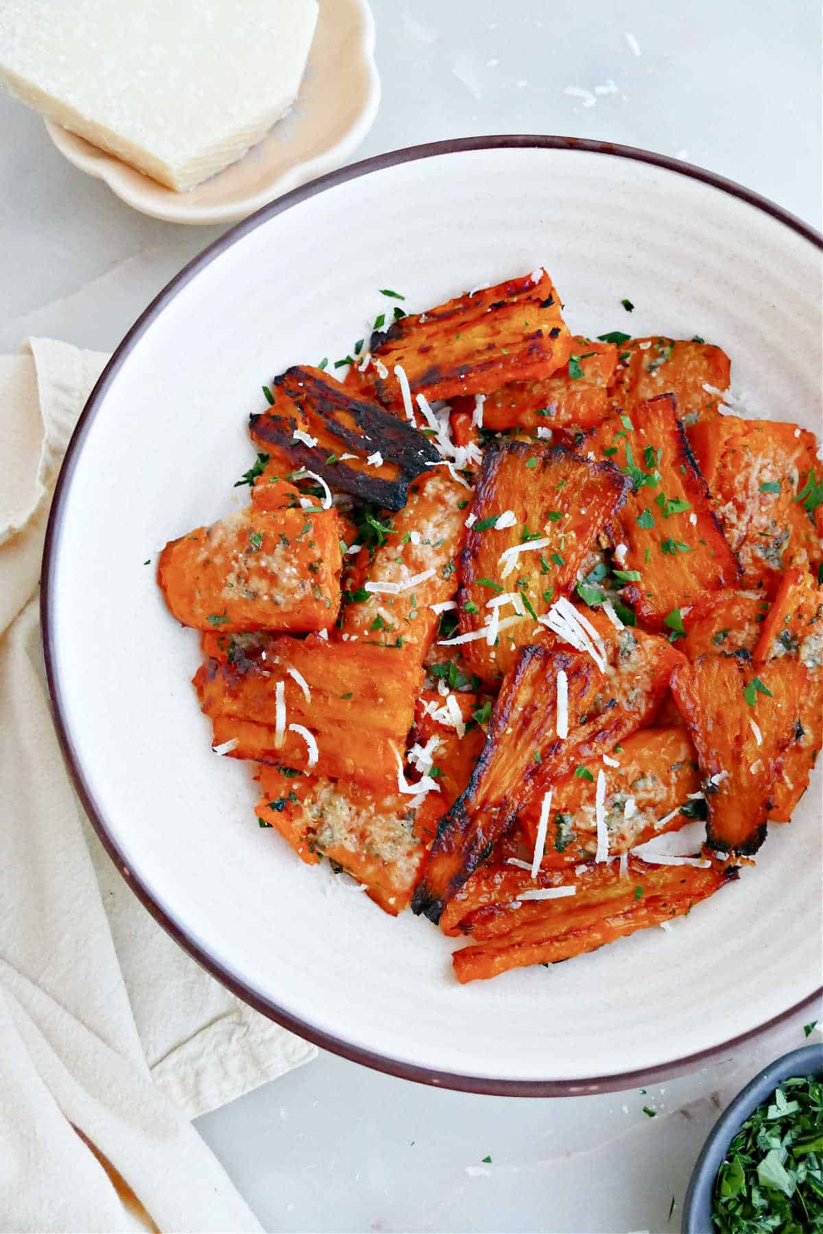 Crispy smashed carrots with cheese and herbs in a bowl.