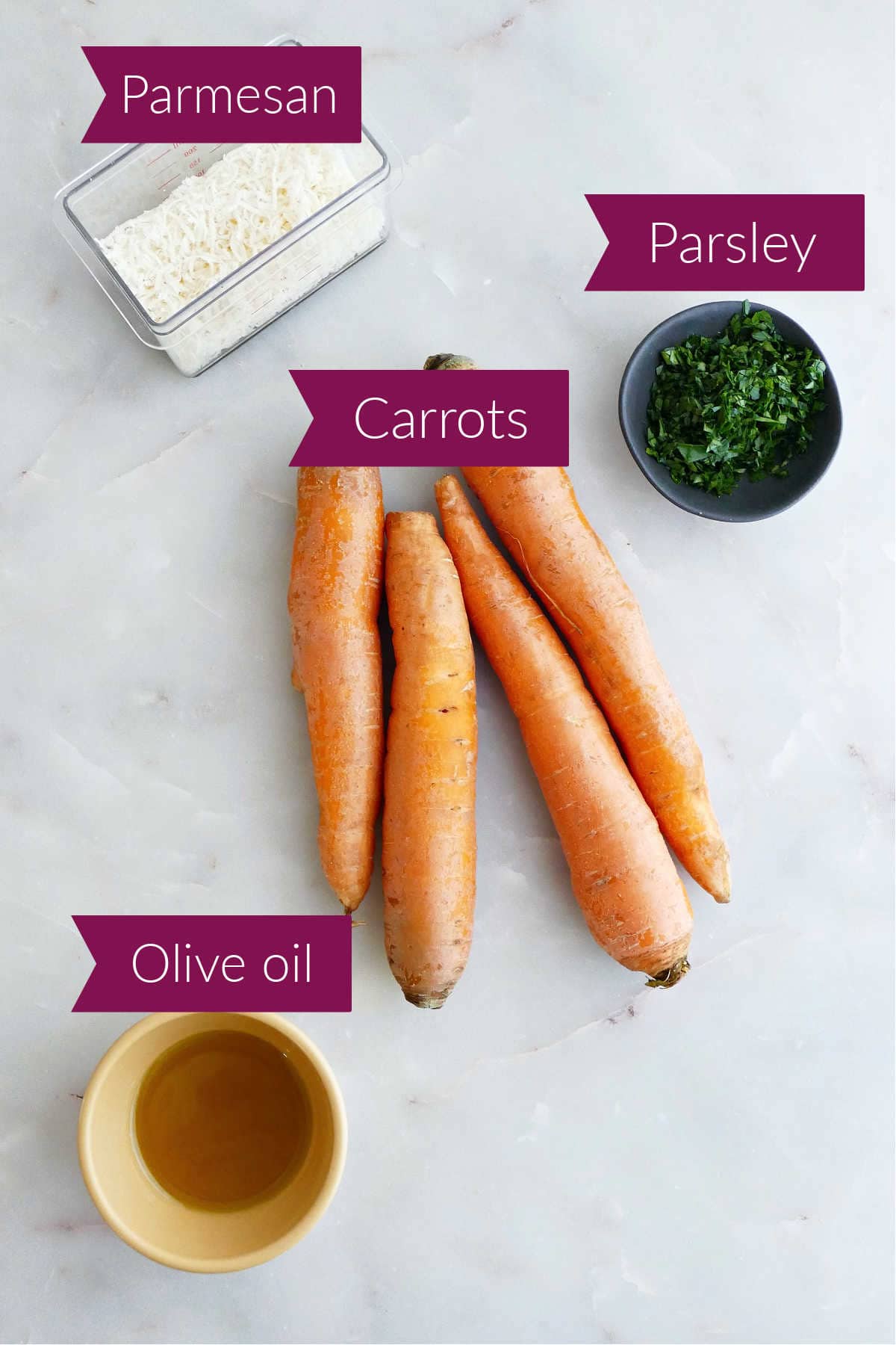 Parmesan cheese, carrots, parsley, and olive oil on a counter with labels.