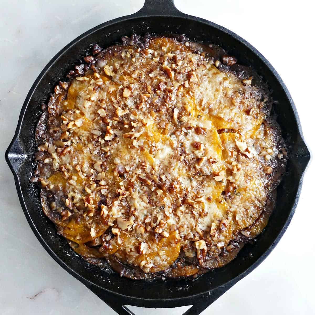 Butternut squash gratin in a cast iron skillet after coming out of the oven.