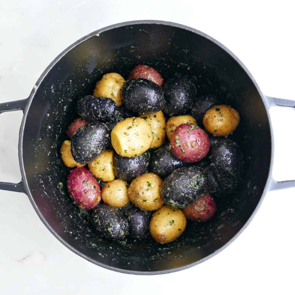 Rainbow baby potatoes in a dutch oven before being roasted.
