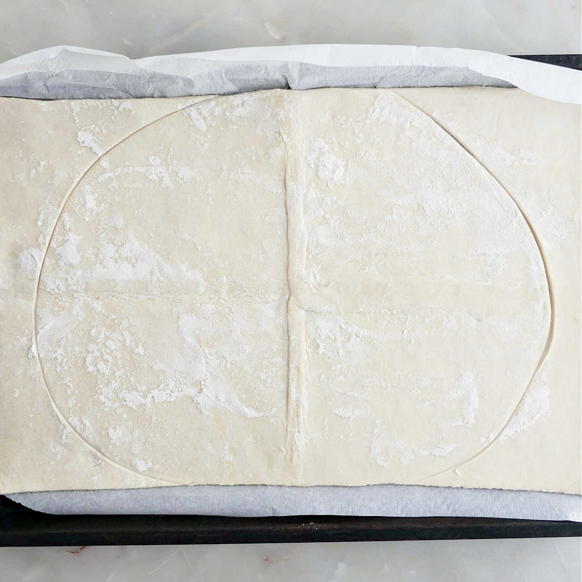 Puff pastry on a lined baking sheet cut into a circle.