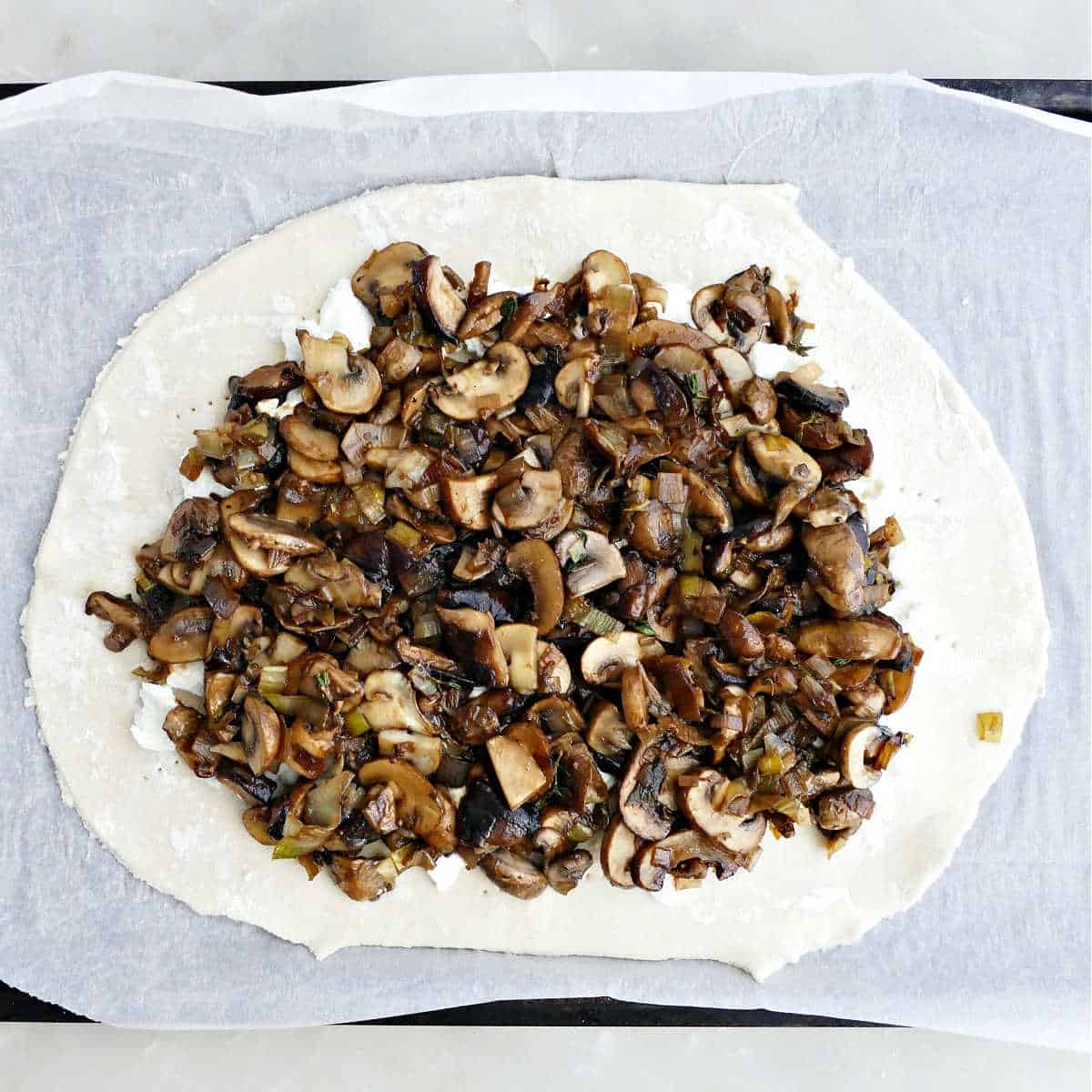 Puff pastry with goat cheese and cooked mushrooms and leeks on top.