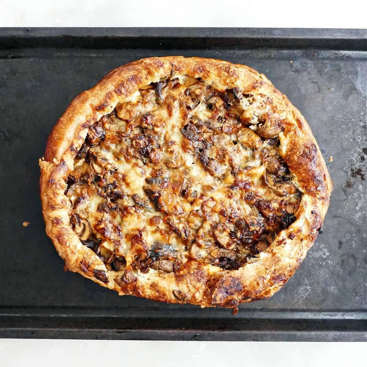 Mushroom galette on a baking sheet after coming out of the oven.
