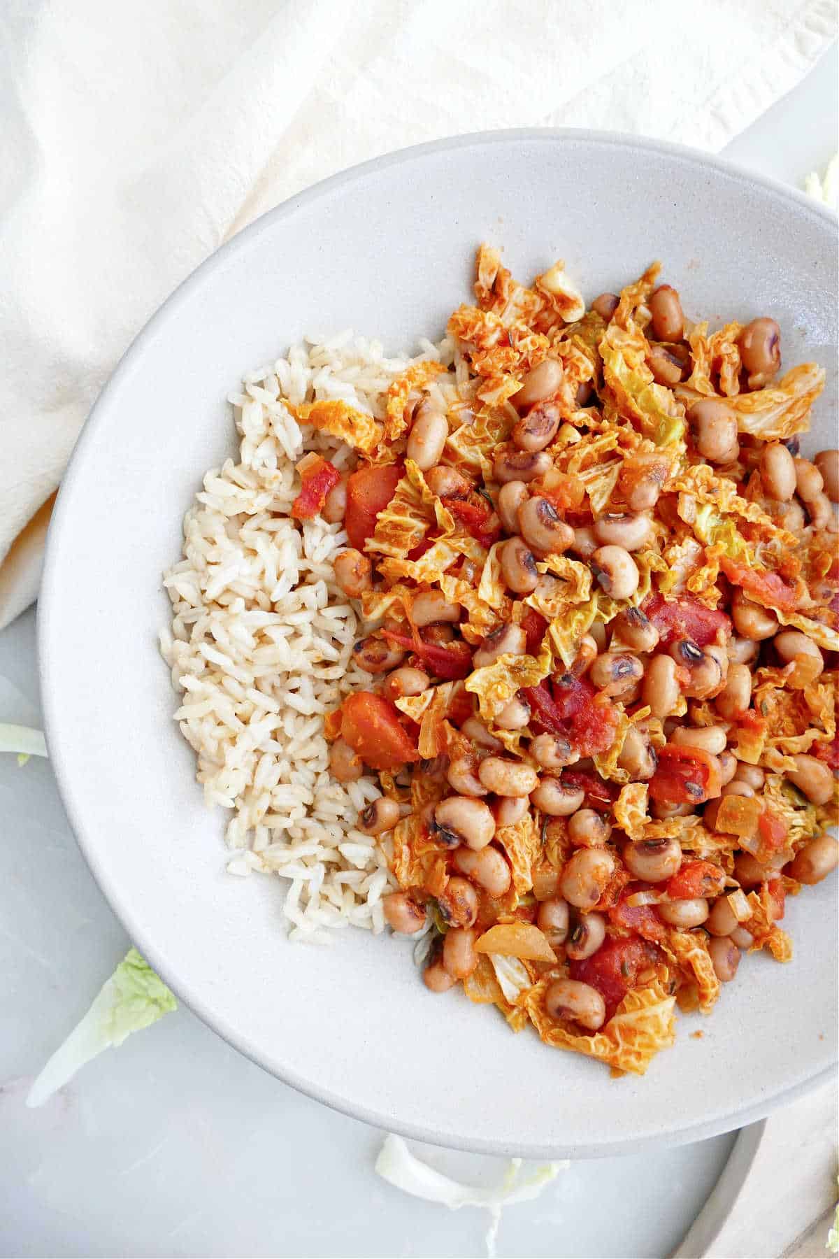 Black eyed peas and cabbage served over rice in a bowl.