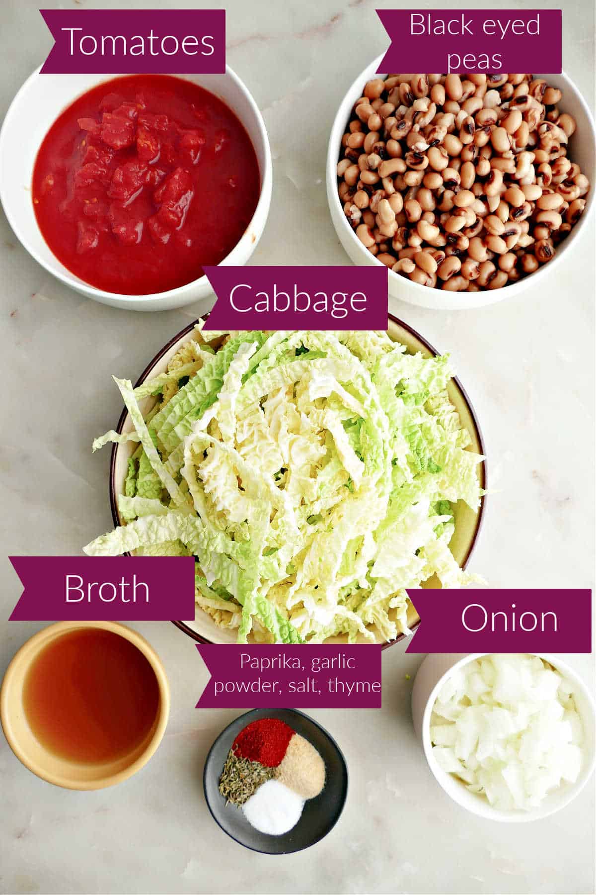 Tomatoes, black eyed peas, cabbage, broth, spices, and onion on a counter with labels.