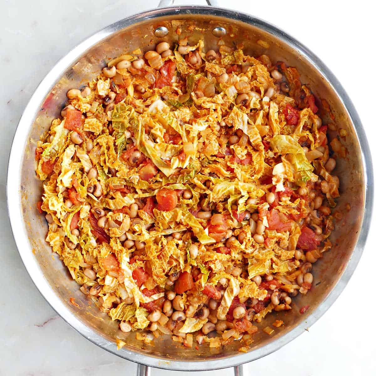 Black eyed peas and cabbage in a skillet after cooking.