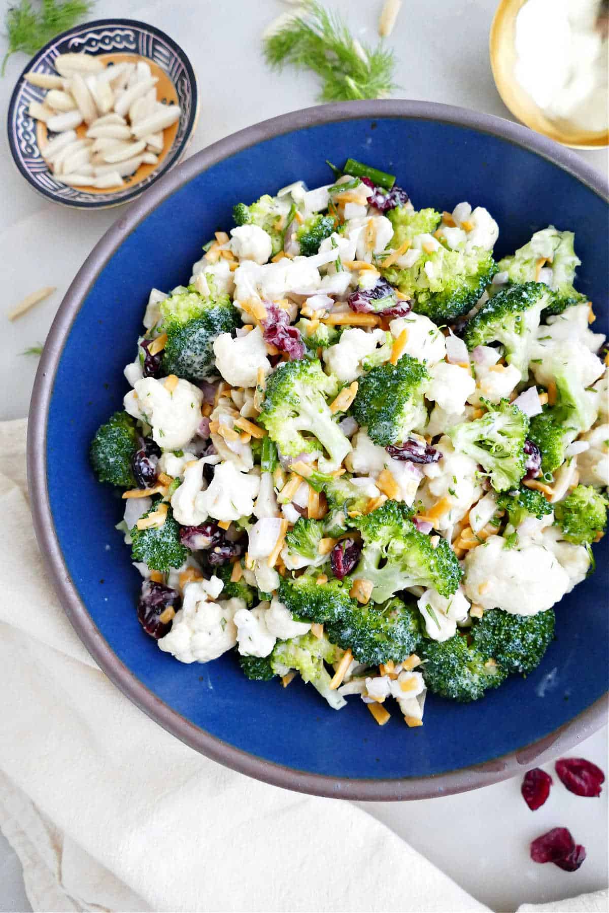 Broccoli and cauliflower salad recipe in a bowl on a counter.
