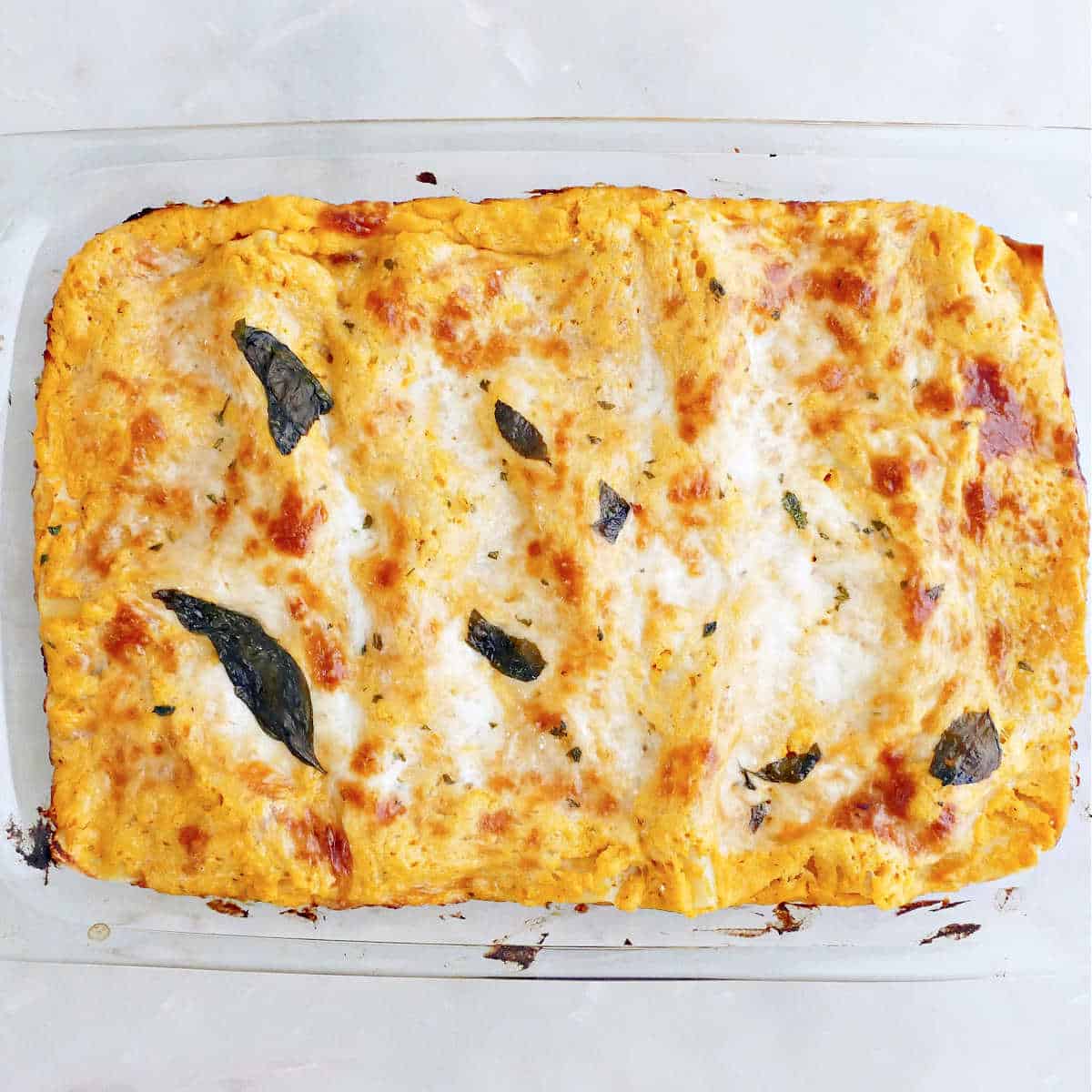 Roasted squash lasagna in a dish after coming out of the oven.