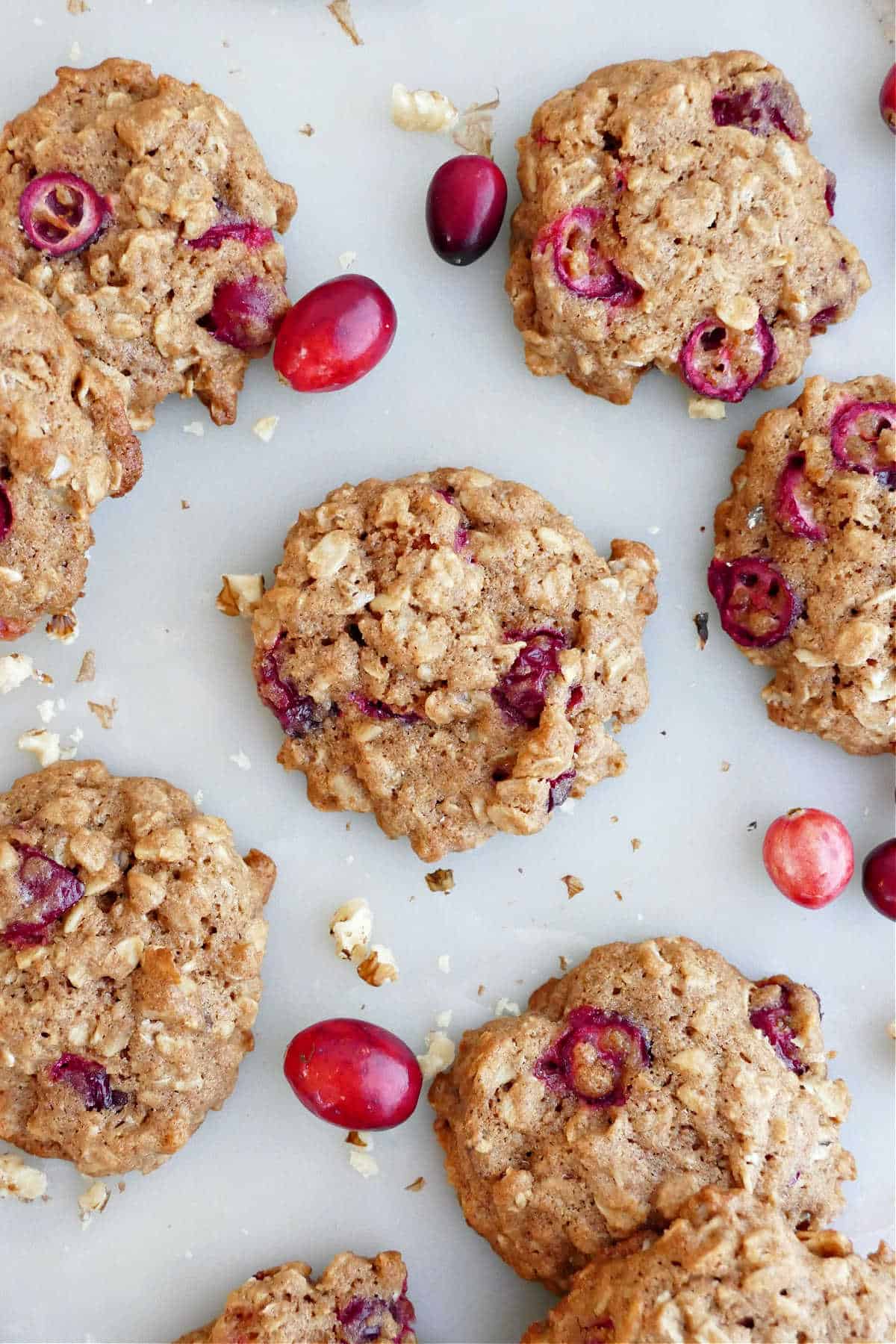 Oatmeal walnut cookies with fresh cranberries on a counter.