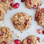 Oatmeal walnut cookies with fresh cranberries on a counter.