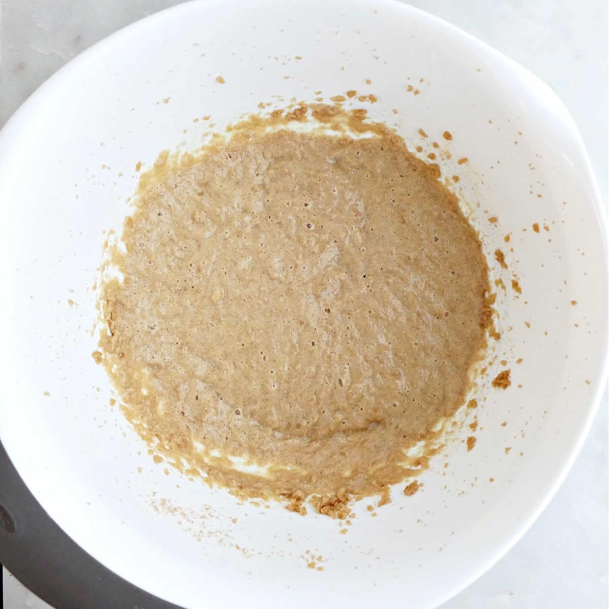 Butter, eggs, vanilla, and brown sugar mixed together in a bowl.