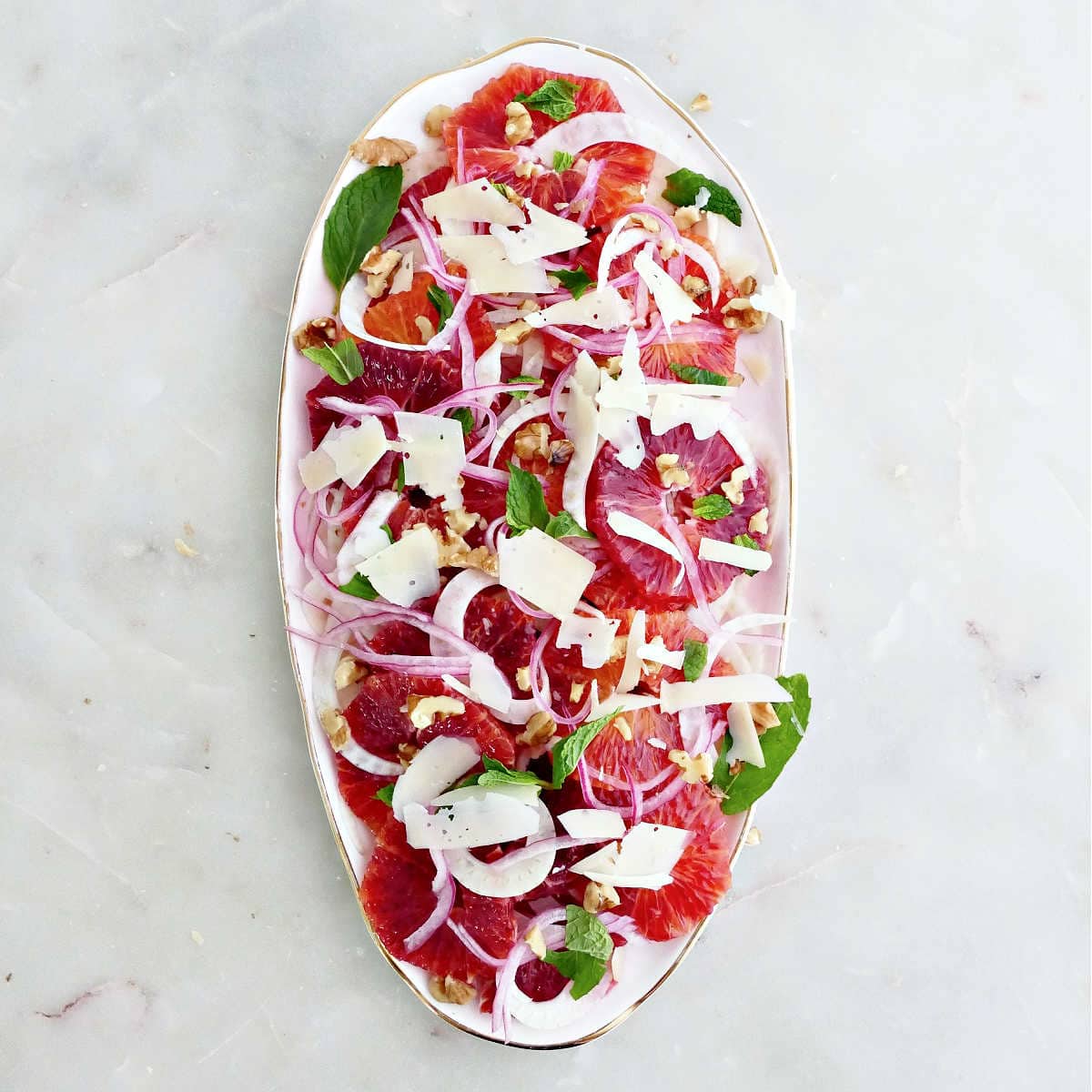 Fennel topped with oranges, pickled onion, mint, cheese, and walnuts.