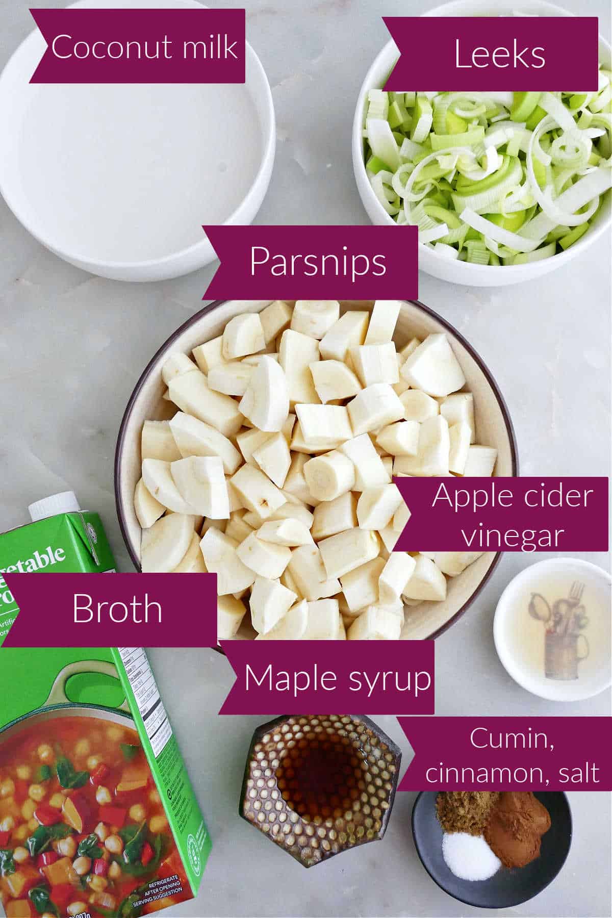 Coconut milk, leeks, parsnips, broth, maple syrup, vinegar, and spices on a counter with labels.