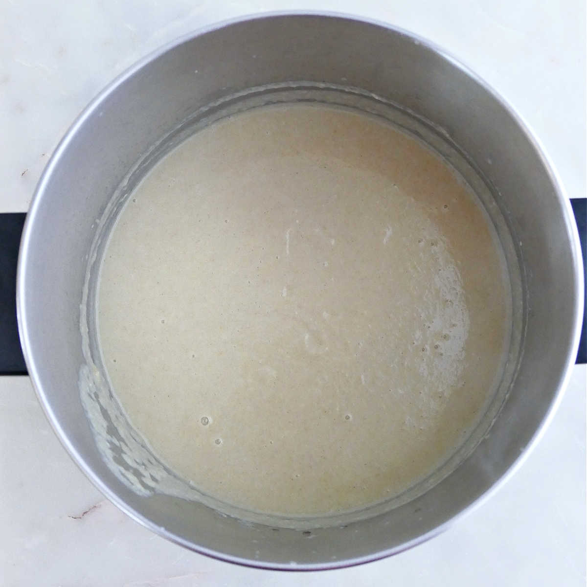 Creamy leek and parsnip soup blended in a soup pot.