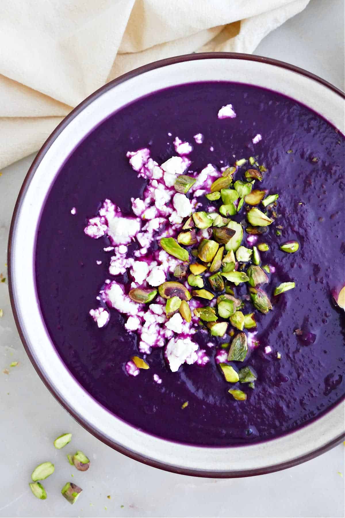 Purple soup with sweet potatoes topped with feta and pistachios.