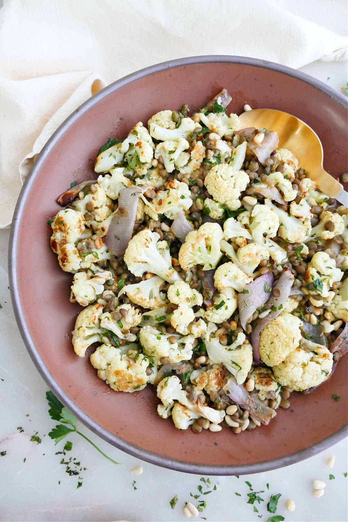 Roasted cauliflower, lentil, and red onion salad in a serving bowl.