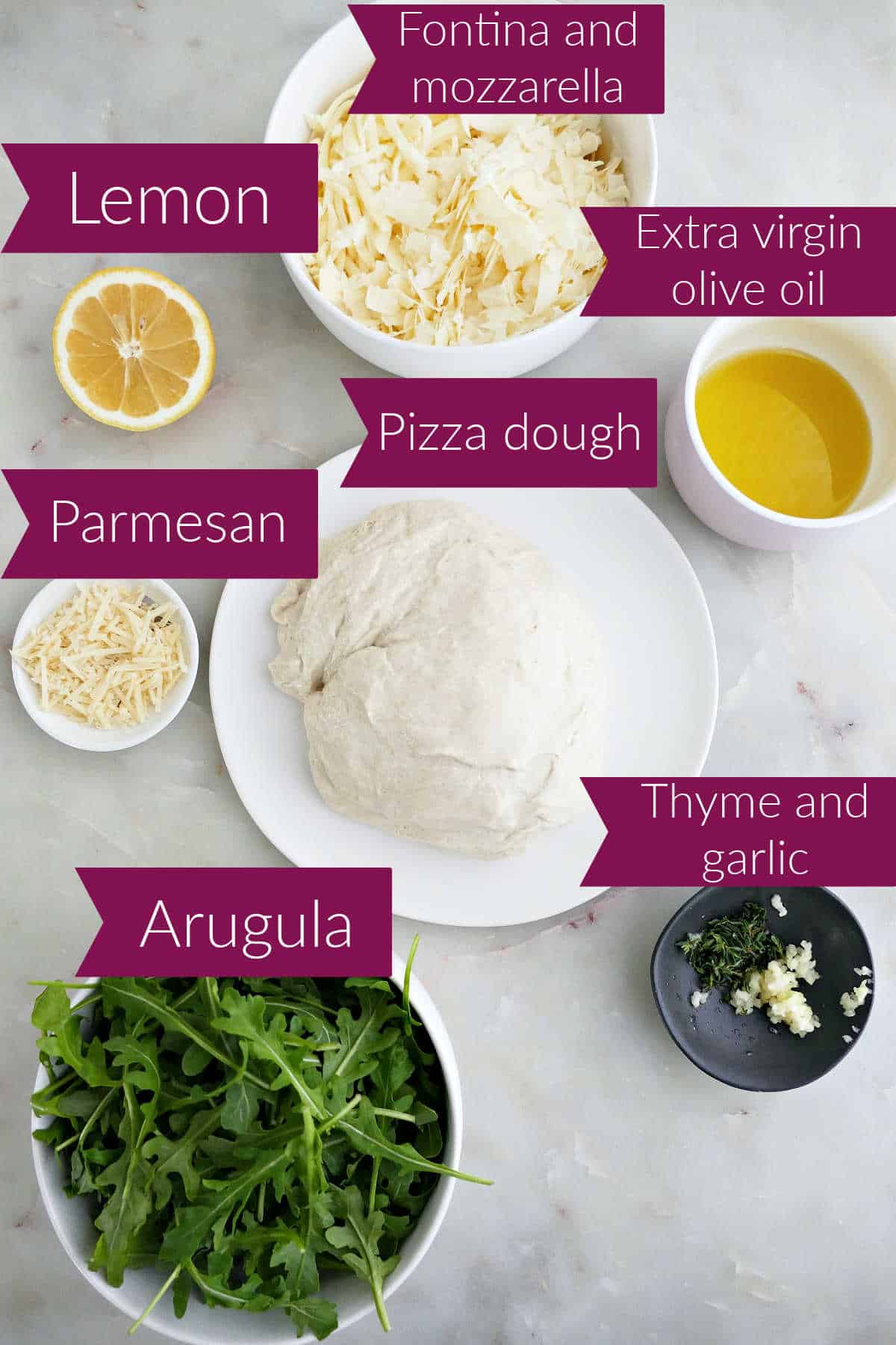 Lemon, shredded cheeses, olive oil, parmesan, pizza dough, baby arugula, garlic, and thyme with labels.