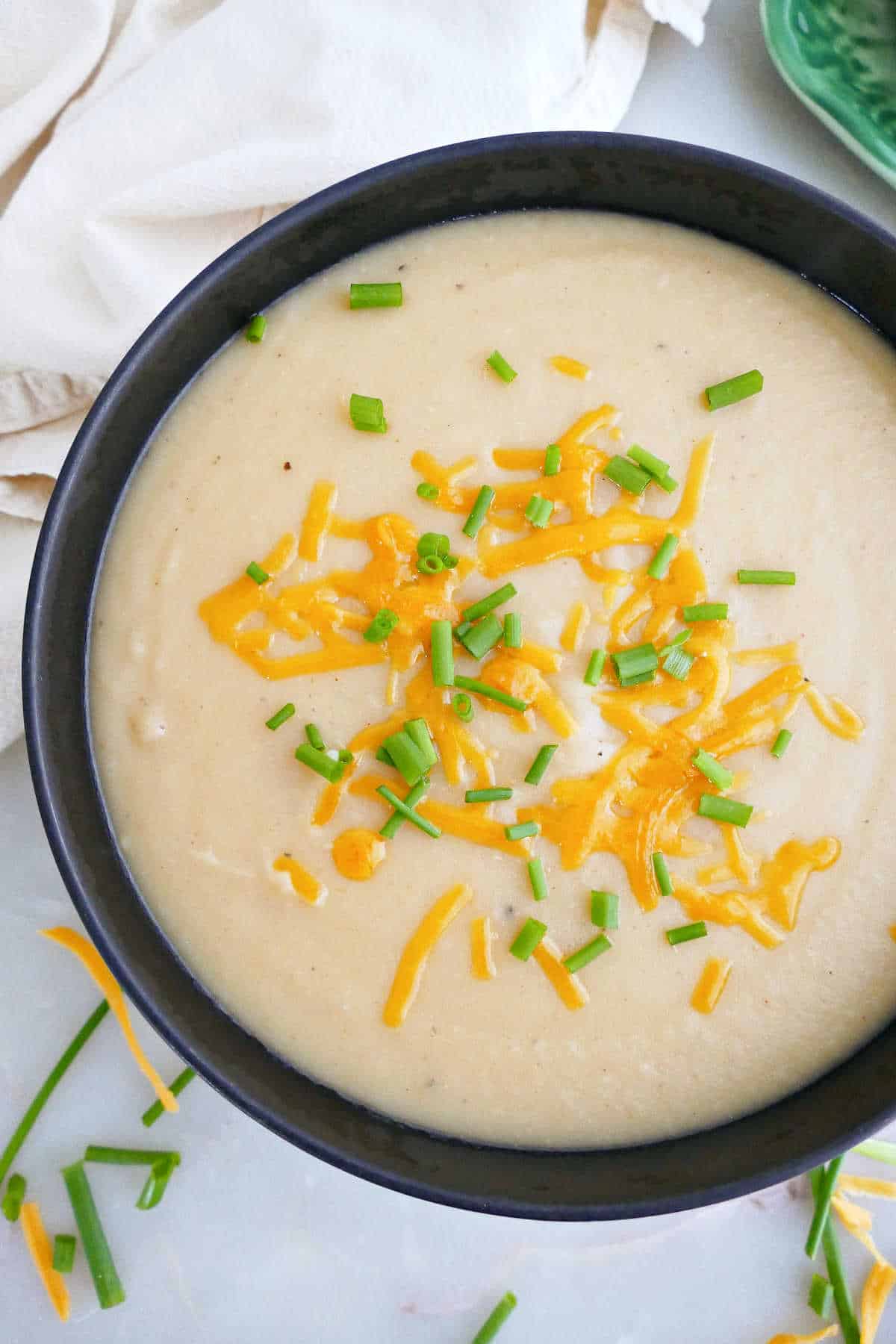 Potato white bean soup topped with shredded cheddar cheese and chives.