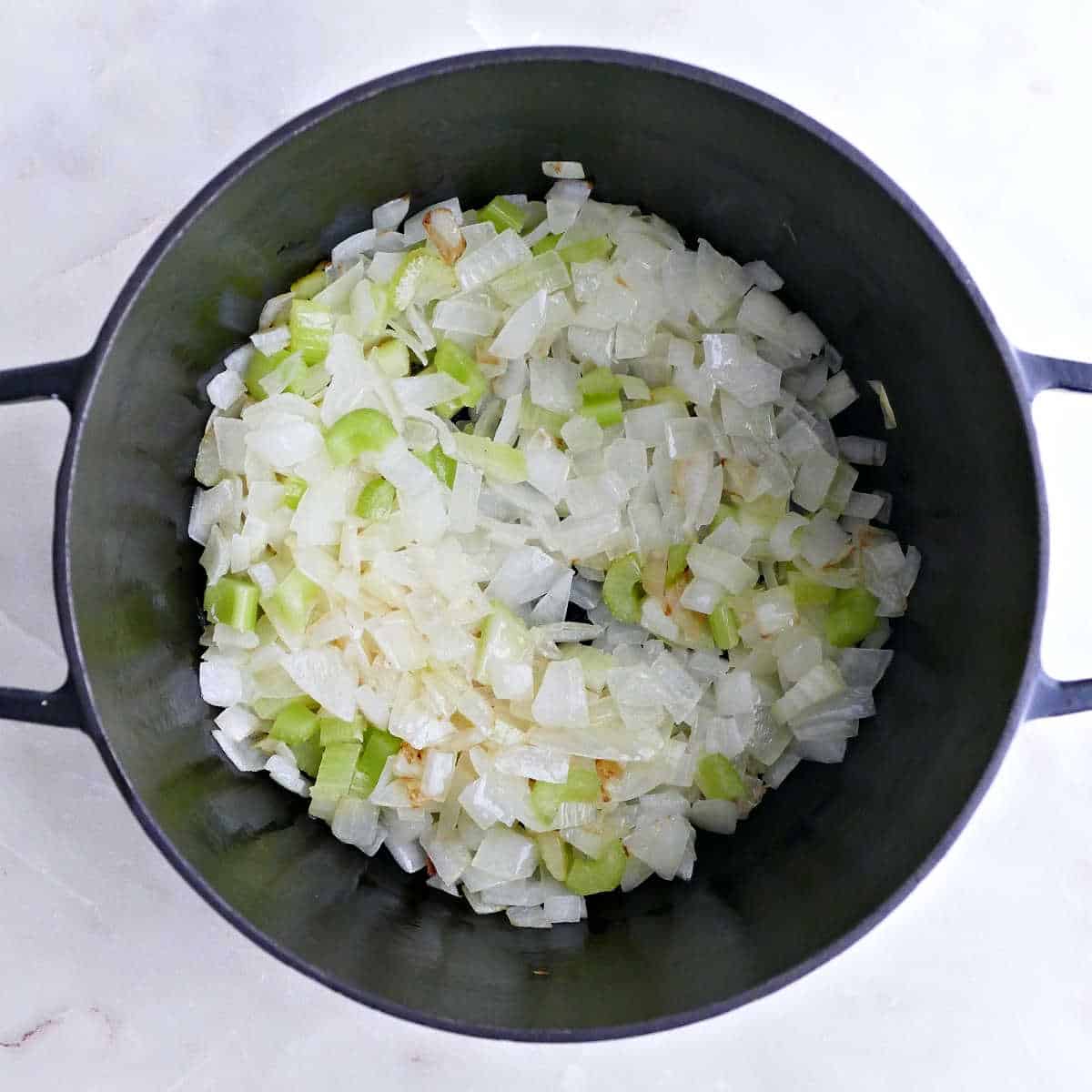 Onions and celery cooking in butter in a large soup pot.