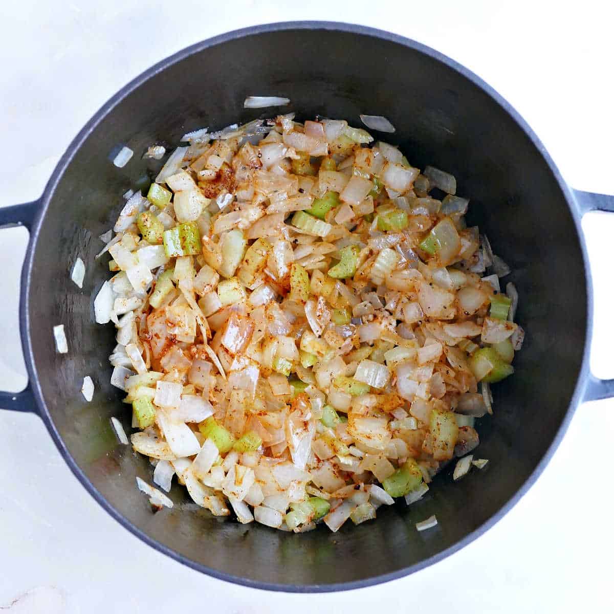Paprika, salt, and pepper added to onions, celery, and butter in a soup pot.