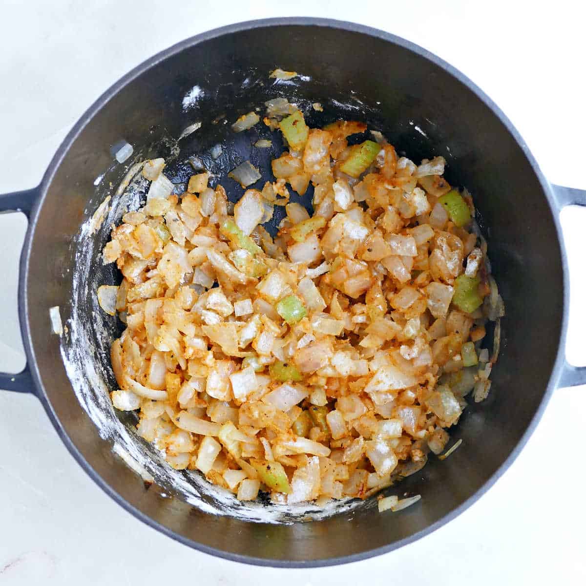 Onions and celery cooked down with spices and flour in a soup pot.