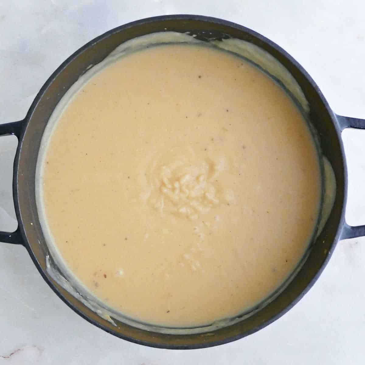 Blended potato white bean soup in a soup pot.