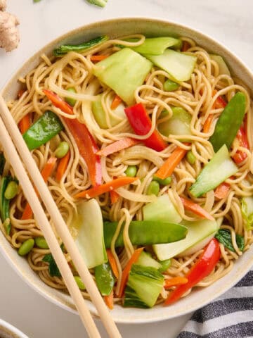 Bok choy stir fry in a bowl with chopsticks on the side.