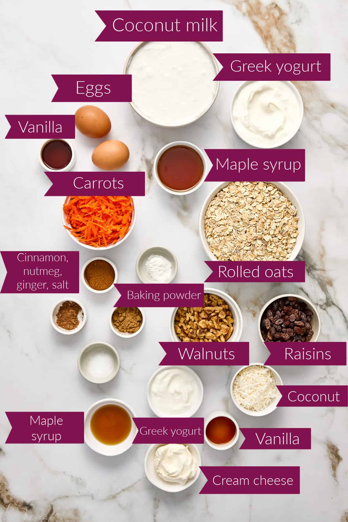 Ingredients for baked oatmeal with shredded carrots in bowls on a counter with labels.