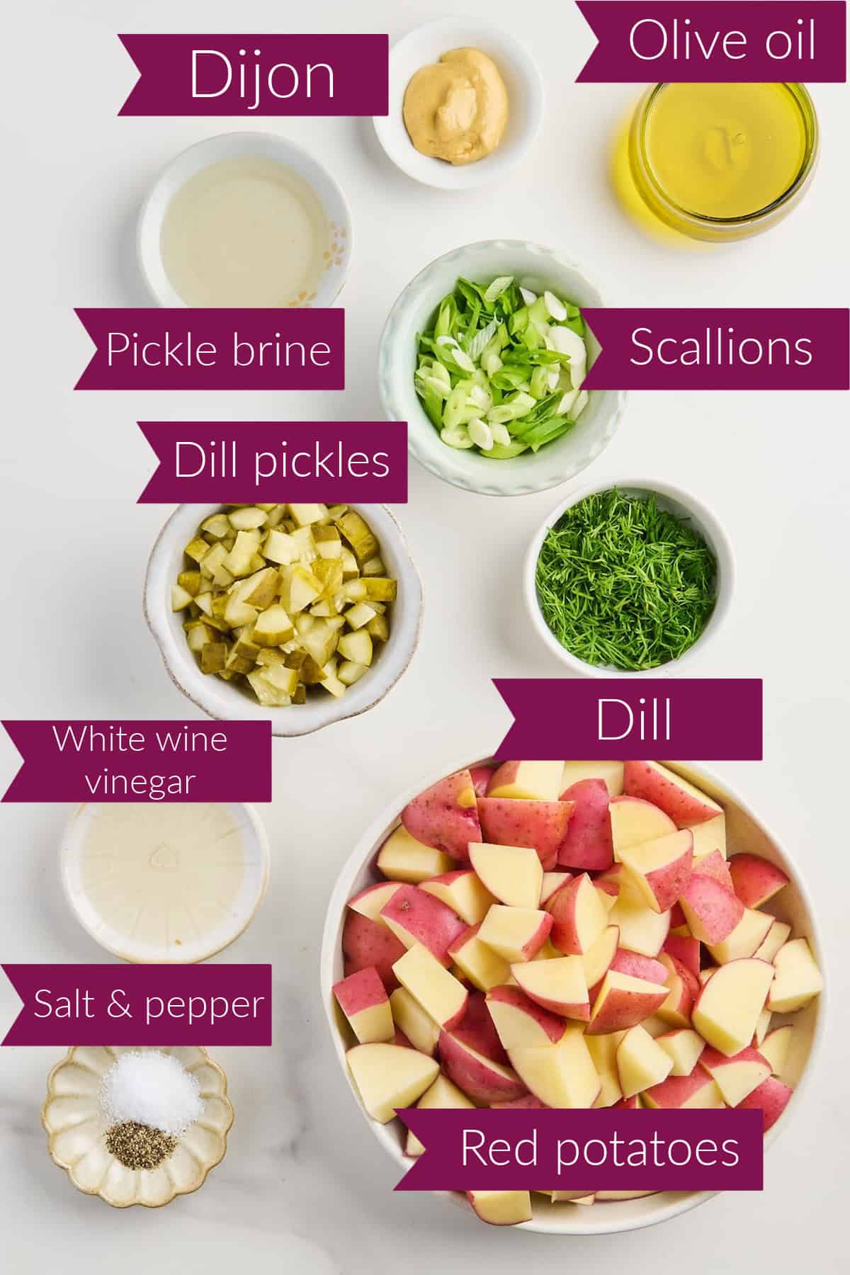 Mustard, oil, pickle brine, scallions, pickles, dill, vinegar, salt and pepper, and potatoes in bowls.