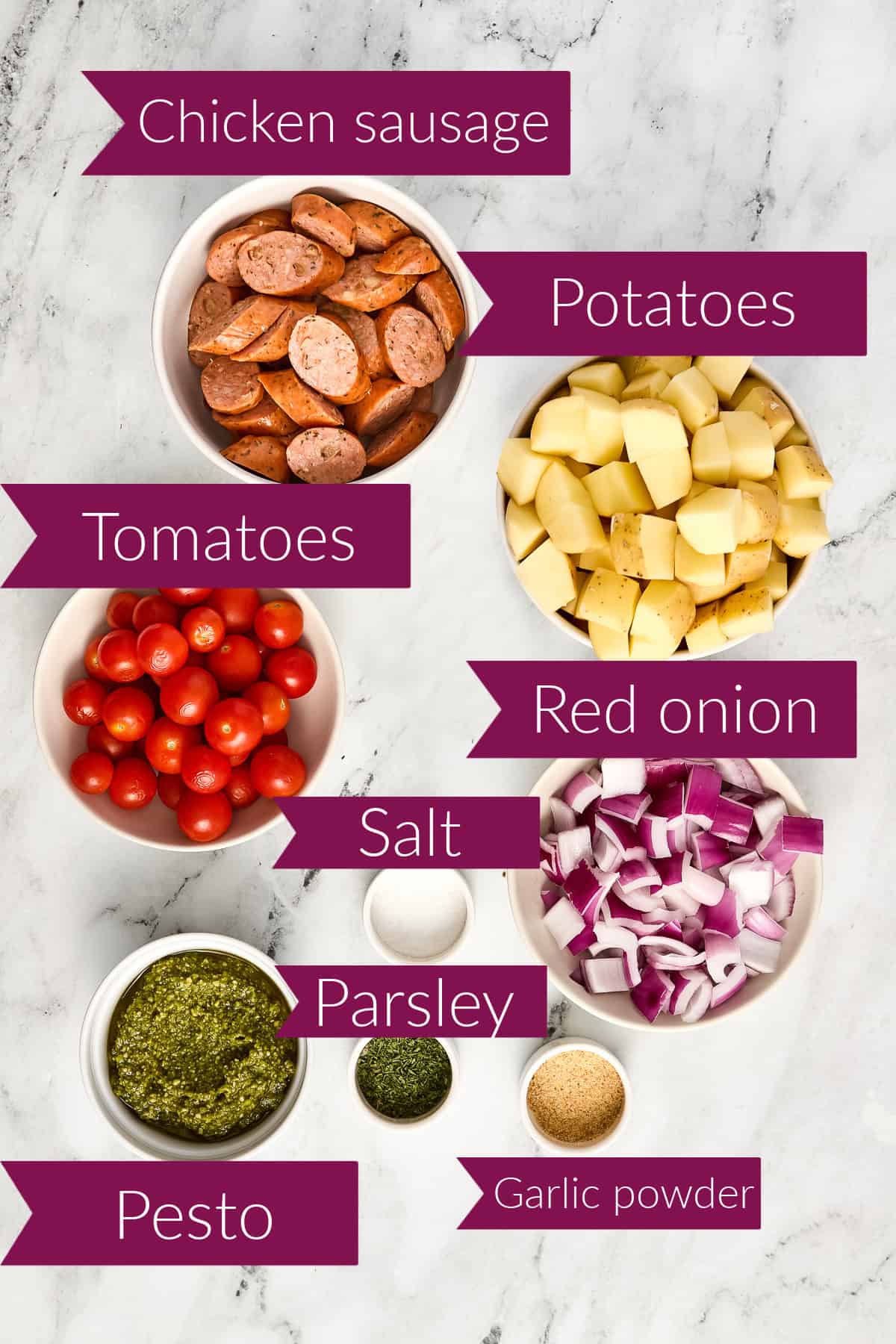 Chicken sausage, potatoes, tomatoes, red onion, salt, pesto, parsley, and garlic powder with labels.