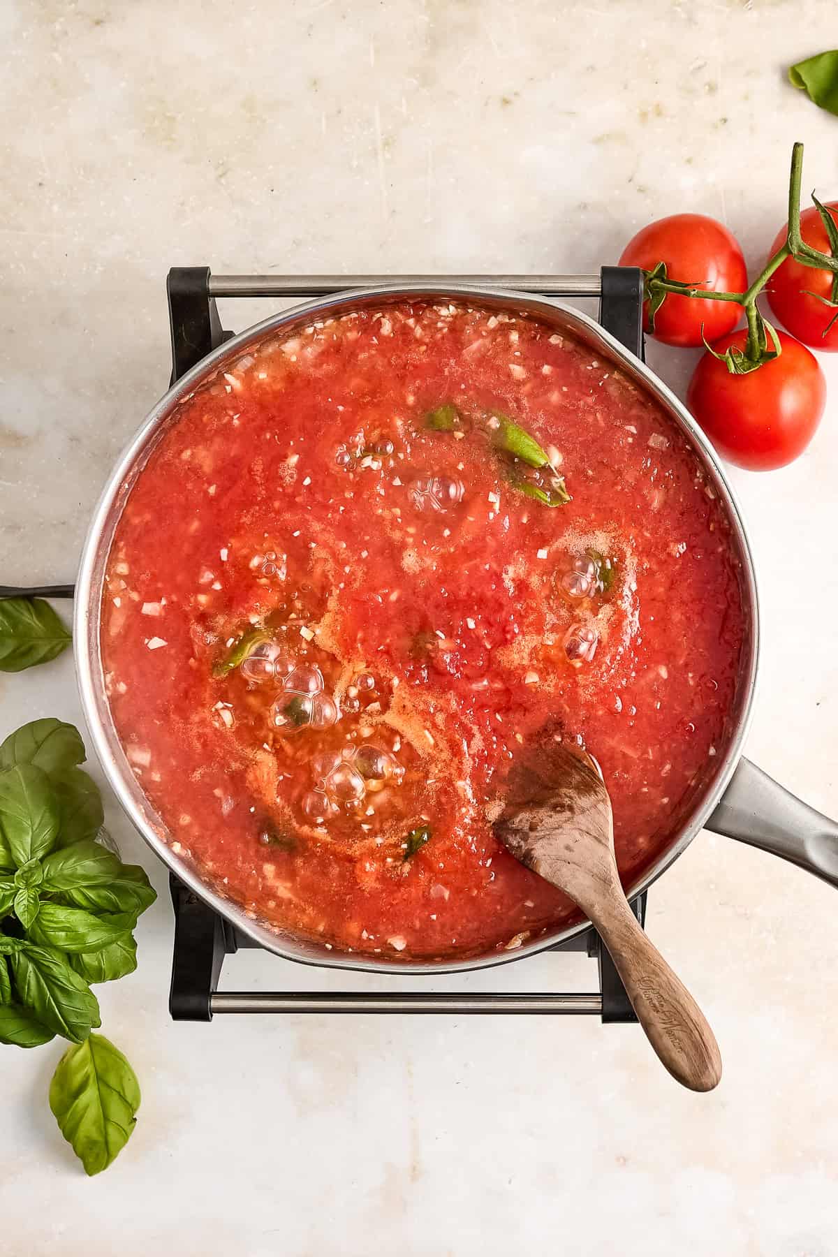 Homemade spaghetti sauce coming to a simmer in a saucepan.